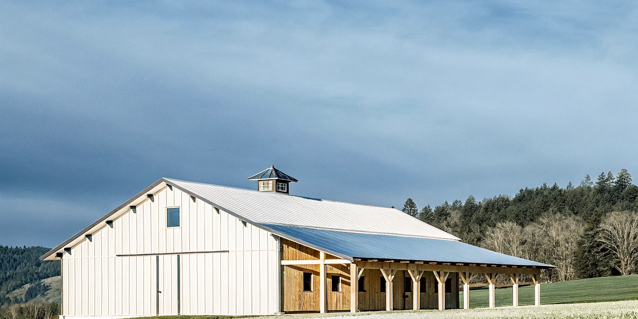 Well-maintained post-frame pole barn in Oregon landscape with metal roof and wooden posts